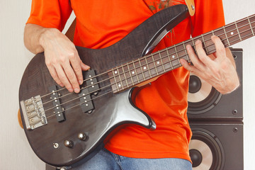 Fototapeta na wymiar Bass guitarist playing the electric bass guitar closeup