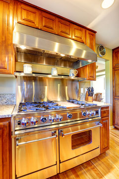 Shiny modern stove with hood in luxury kitchen room