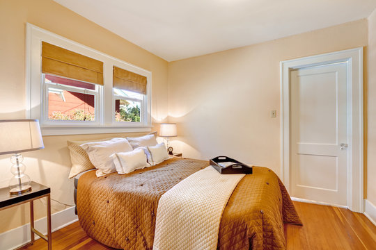 Warm bedroom interior with brown bedding and ivory blanket