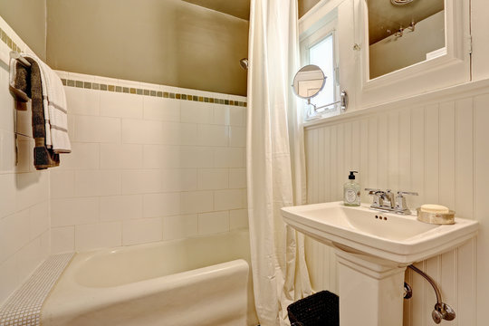Bathroom with plank paneled wall and tile trim
