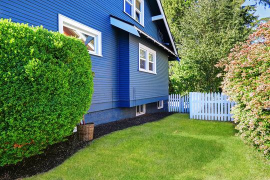 Backyard with lawn and white wooden fence