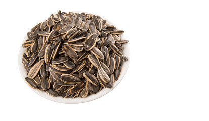 Sunflower seeds in white bowl over white background