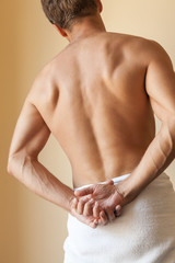 Back of Strong young Caucasian man with white towel