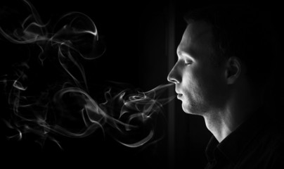 Closeup profile portrait of young man with closed eyes and smoke - Powered by Adobe
