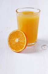 Fresh juice in a glass with an orange half