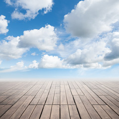 Brown wooden floor with perspective and cloudy sky