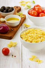 Pasta farfalle before preparation on a wooden background