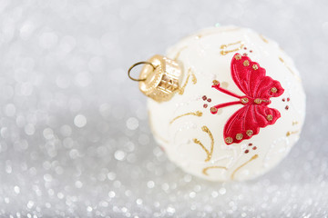 Christmas bauble on abstract silver glitter blurred background