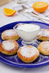 Fritters of cottage cheese with sour cream on a white background