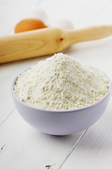 Flour in bowl with eggs and rolling pin