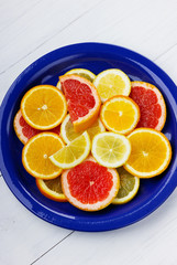 Citrus fruits slices in a blue ceramic plate