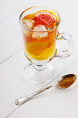 Glass of ice tea with citrus on a light background