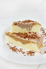 Pie with icing sugar and chocolate on a white plate