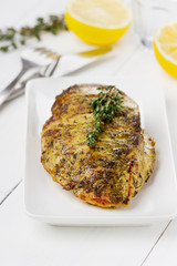 Chicken fillet with thyme on a white plate