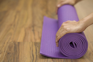 Fototapeta na wymiar Young woman holding a yoga mat