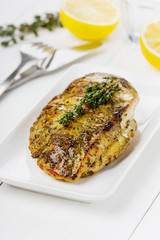 Chicken fillet with thyme on a white plate