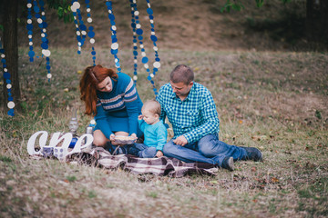 Happy family have birthday party with blue decorations in forest