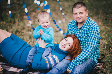 Naklejka premium Happy family have birthday party with blue decorations in forest