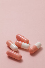 Pink pills on pink background