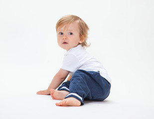 Kleiner Blonder Junge sitzt und schaut