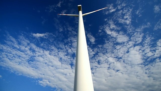 hohes windrad mit blauem himmel ganz nah in zeitraffer