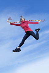 Fototapeta na wymiar Happy girl jumping over blue sky