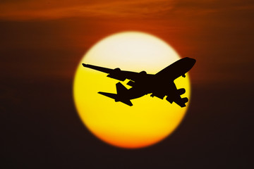 Silhouette of airplane on sunset
