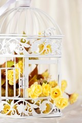 Open decorative cage with yellow flowers