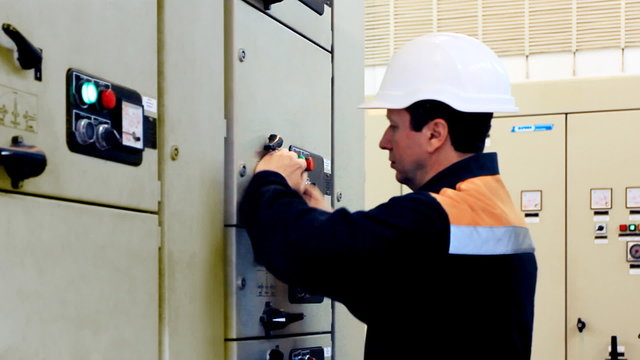 engineer unlocks and activates electrical equipment, closeup