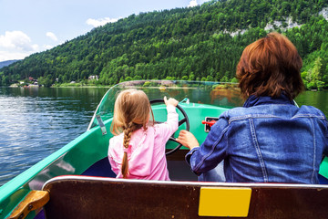 Fototapeta premium Little girl driving rental boat