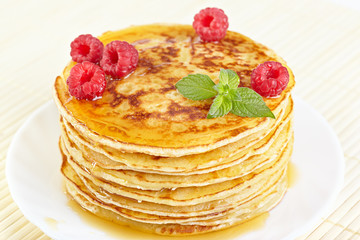 Pancakes with honey, raspberry and a mint branch
