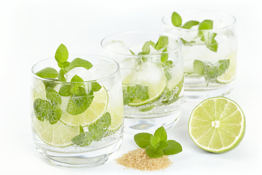Three glasses with Mojito cocktail on a white background