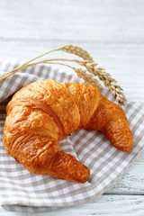 croissant and ears of wheat on a towel