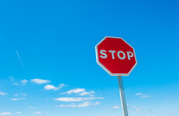 Stop sign over blue sky background