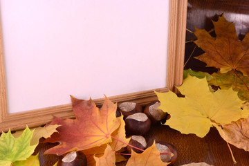 autumn chestnuts on wooden background and blank paper card