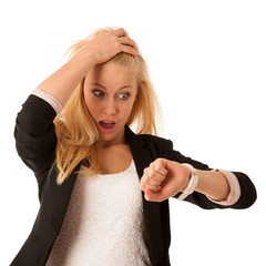 Young blonde woman looks at her watch when she is being late iso