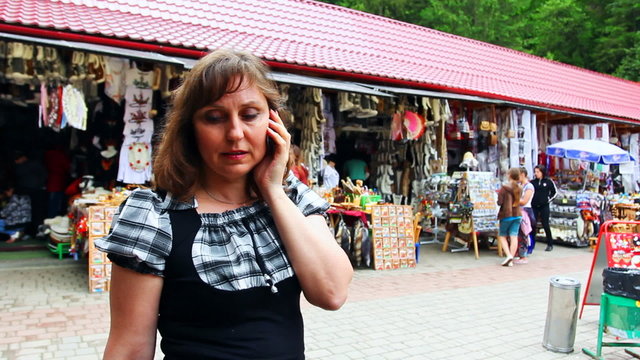 nice woman speaks by phone on Souvenir Market Yaremche, Ukraine