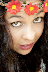 Naklejka premium Beautiful woman with a wreath of red flowers on her head in a pa