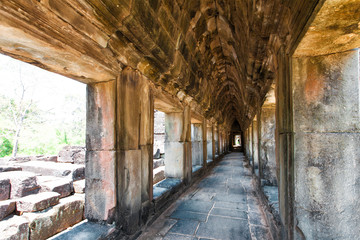 Fototapeta na wymiar The ancient ruins of a historic Khmer temple in the temple compl