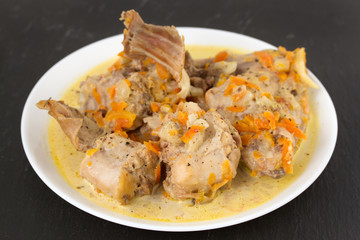 rabbit with sauce on plate on black background