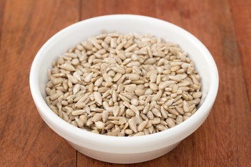 sunflower seeds in white bowl on dark background