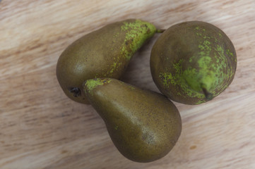 Green pears on wooden table background
