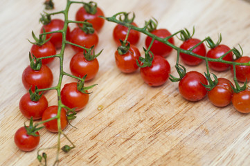 Some red cherry tomatoes in wooden background