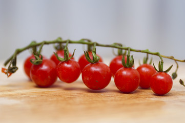 Some red cherry tomatoes in wooden background