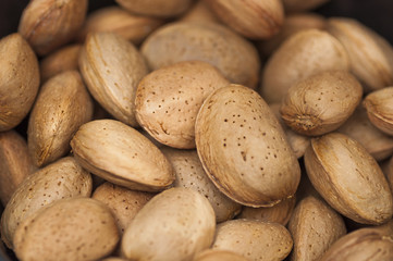 Obraz premium Some almonds in wooden background