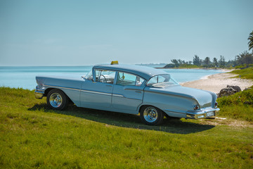 Obraz na płótnie Canvas View of vintage retro classic car parked at the beach