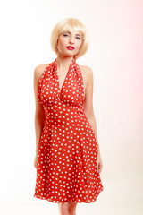 Portrait beautiful pinup girl in blond wig retro red dress