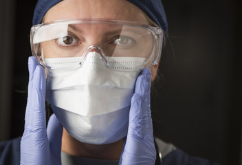 Female Doctor or Nurse Putting on Protective Facial Wear