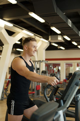Obraz na płótnie Canvas Merry young man exercising on treadmill