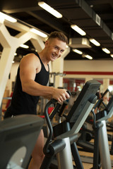 Fototapeta na wymiar Cheerful runner posing at camera in gym